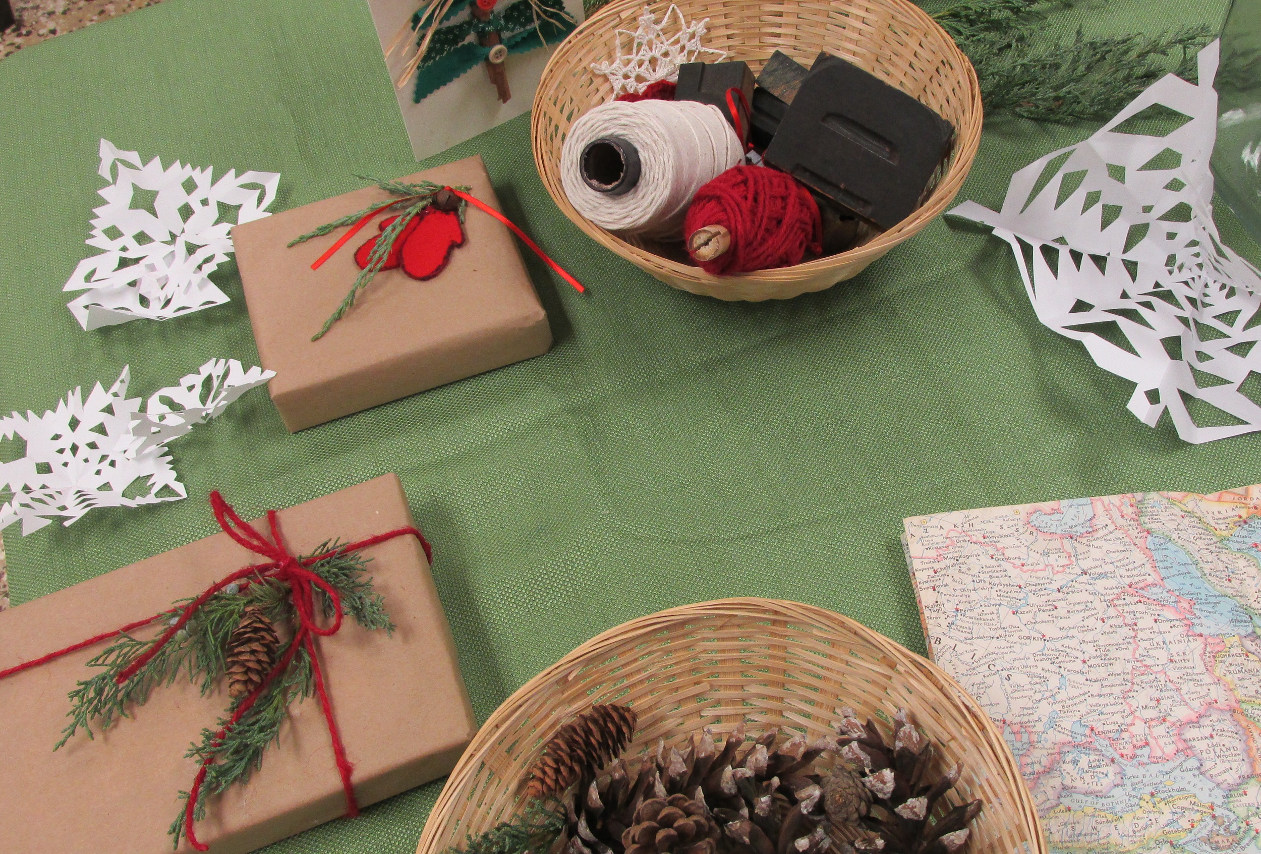 Table with wrapped presents, paper snowflakes, and pinecones