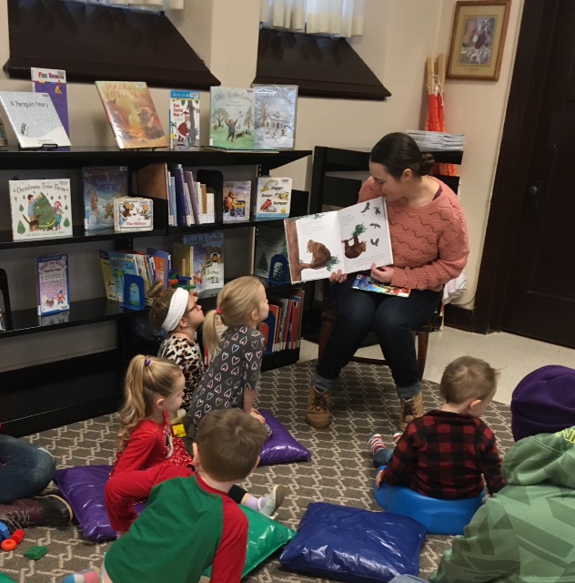 Librarian reads to a group of kids during Story Time