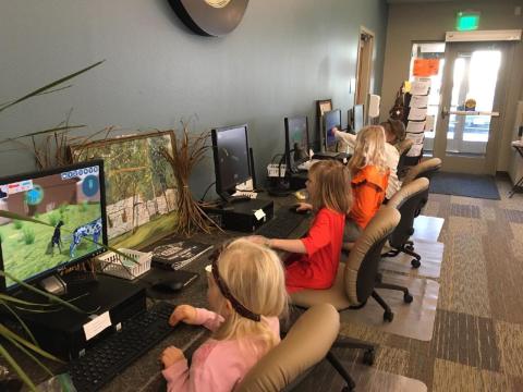 Four children use computers at the library